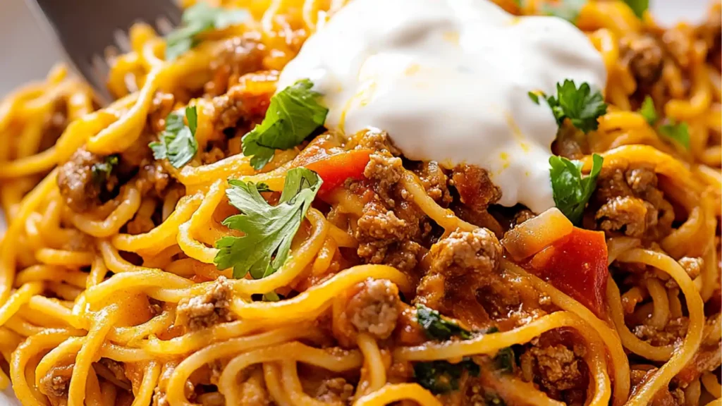 bowl filled with taco spaghetti and topped with cheese
