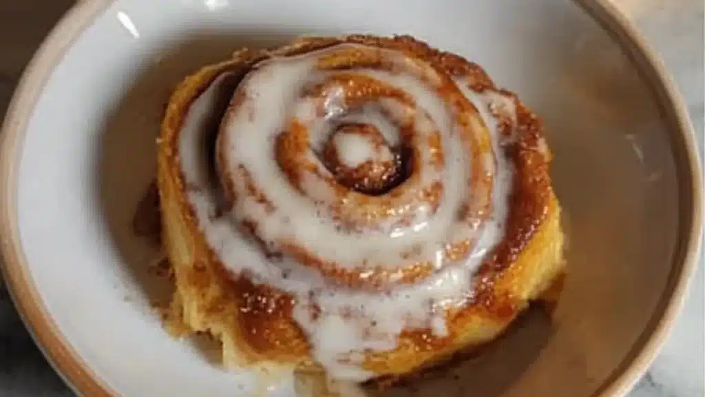 pumpkin cinnamon rolls on a plate with a fork